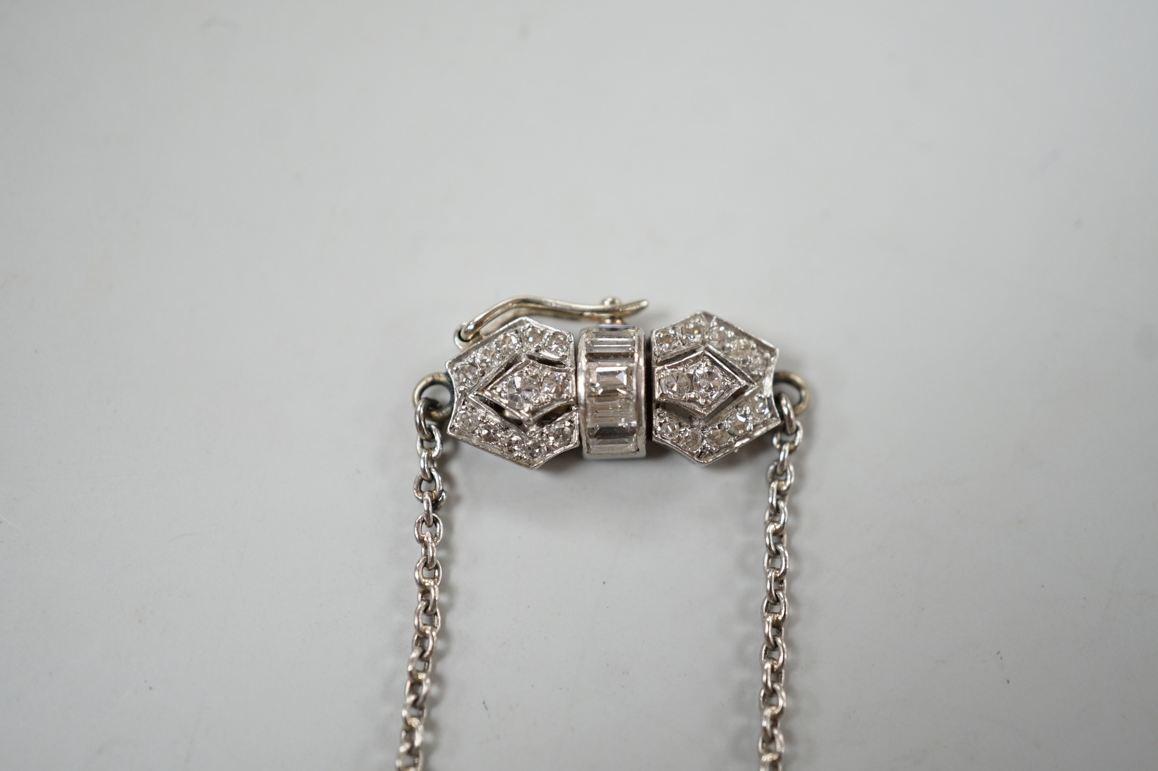 An early to mid 20th century white metal, baguette and round cut diamond set clasp chain, approx. 38cm (knot), gross weight 7.4 grams.